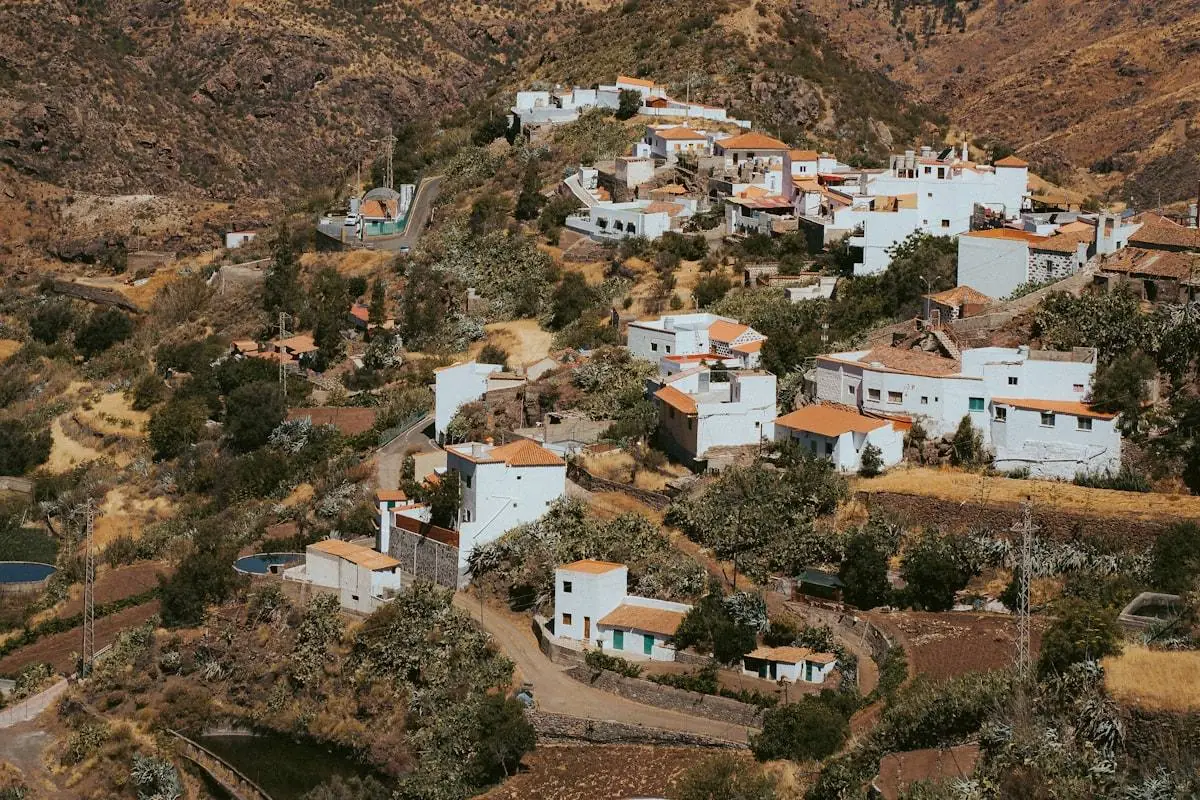 Poble de muntanya de la Garrotxa amb una persona mirant el mòbil vora una finestra