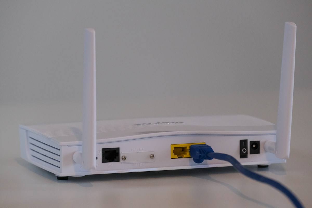 Router WiFi domèstic sobre una taula del menjador amb els llums encesos