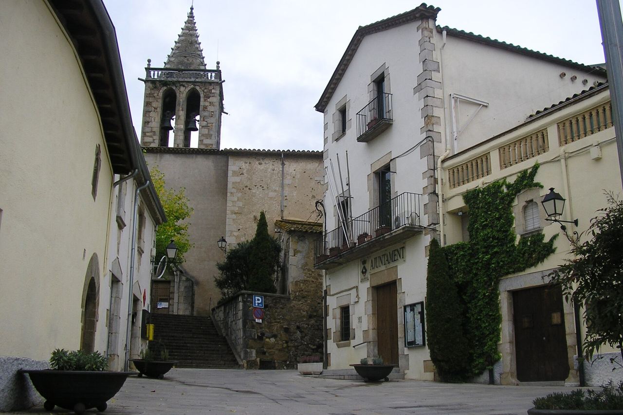 La plaça de la Constitució d'Aiguaviva, amb l'Ajuntament a la dreta i unes escales que pugen cap al campanar de l'església