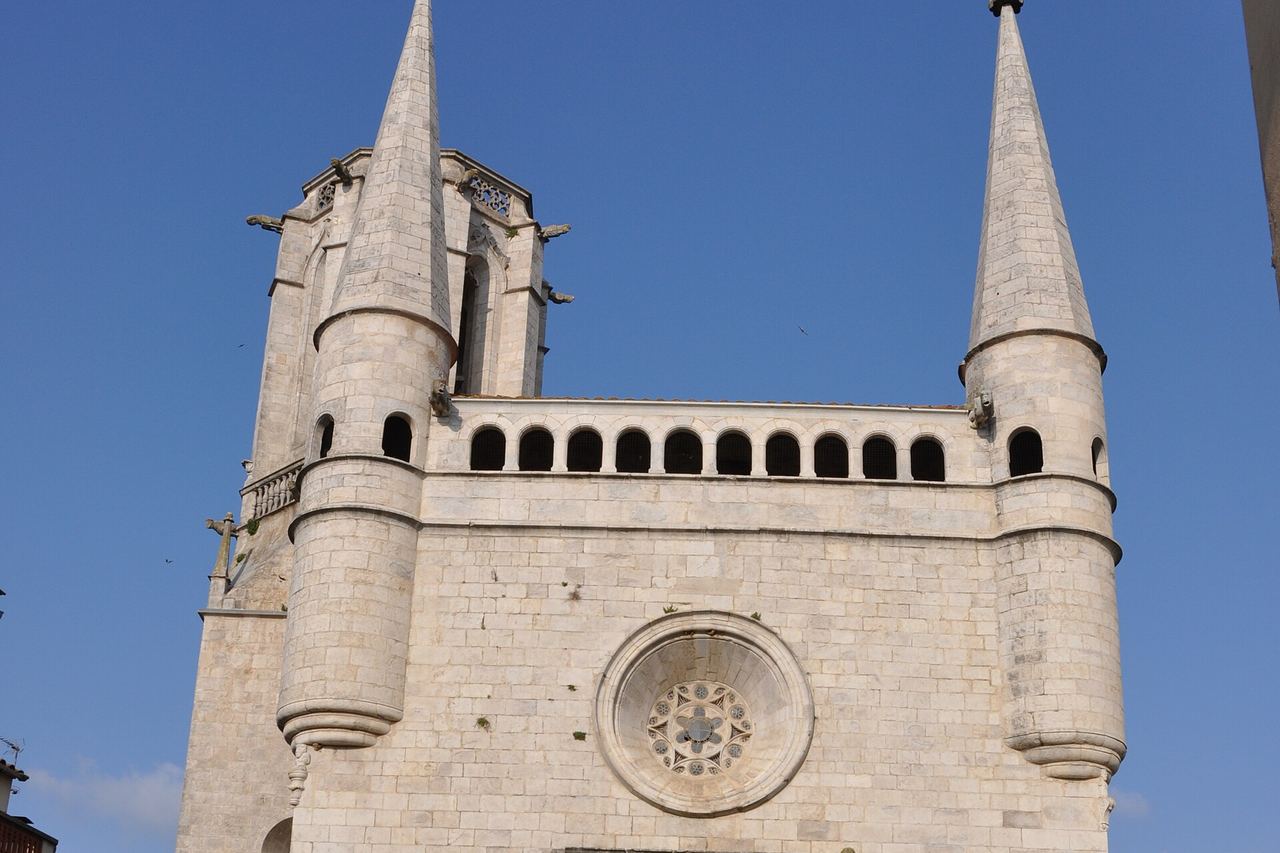 La façana de l'església de Sant Esteve de Bordils, de pedra clara, amb la rosassa, dues torretes punxegudes i el campanar