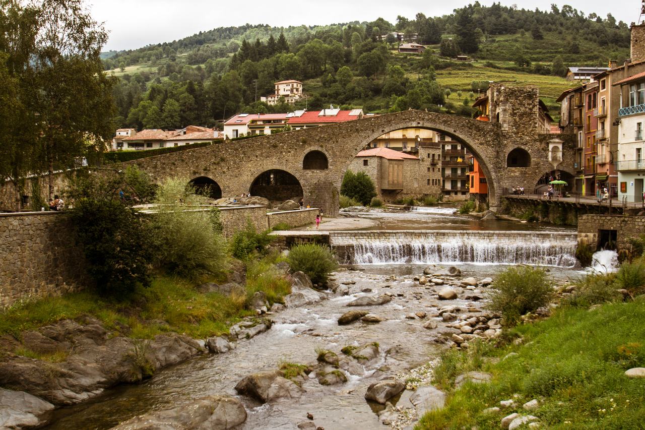 El Pont Nou de Camprodon sobre el riu Ter, amb les cases del poble i les muntanyes al fons