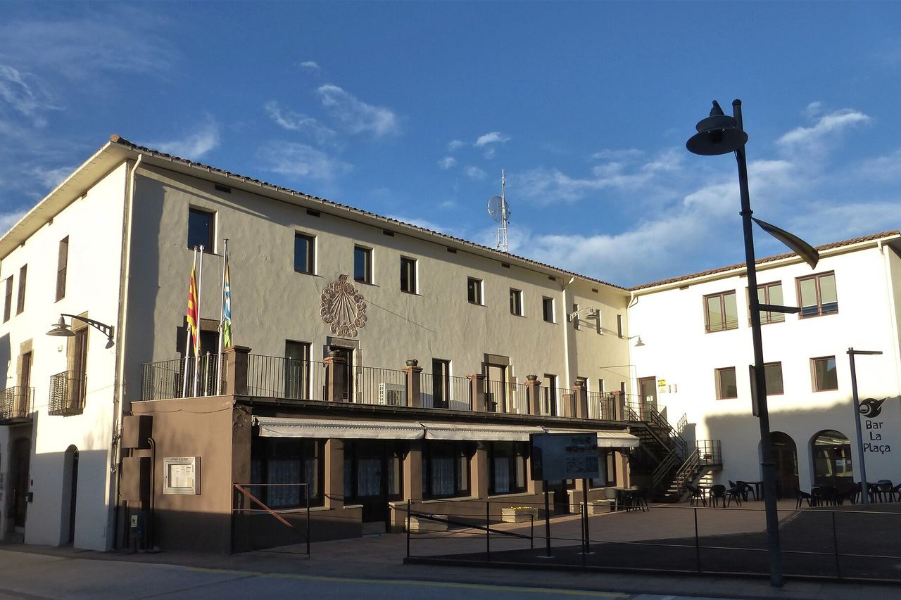 L'antic convent de les Carmelites de les Preses, amb un rellotge de sol a la façana i banderes al balcó