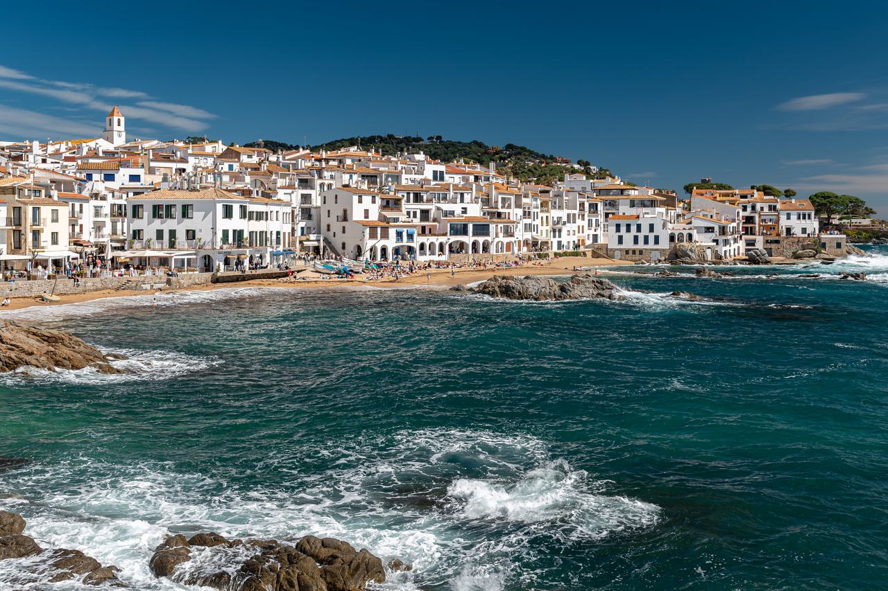 Calella de Palafrugell amb les cases blanques sobre la cala i el mar en primer terme