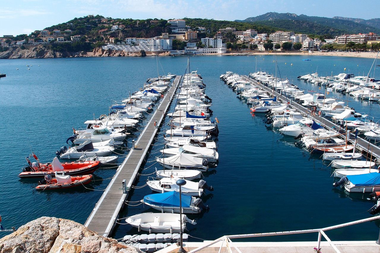 El puerto deportivo de Sant Feliu de Guíxols con las barcas amarradas y la bahía al fondo